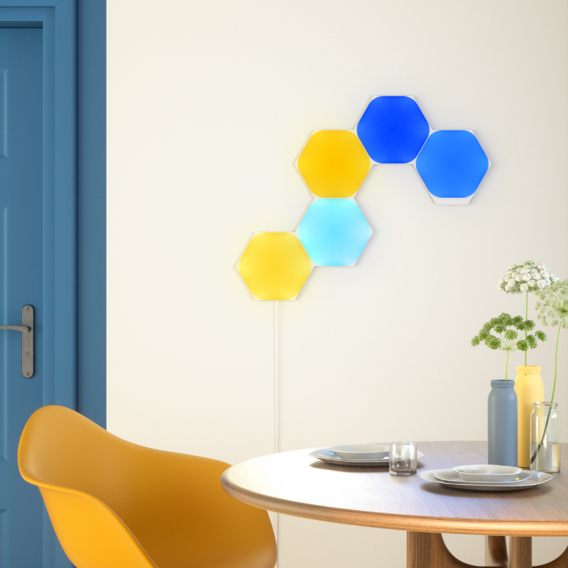 Nanoleaf Shapes Thread enabled color changing hexagon smart modular light panels mounted to a wall in a dining room. Similar to Philips Hue, Lifx. HomeKit, Google Assistant, Amazon Alexa, IFTTT.